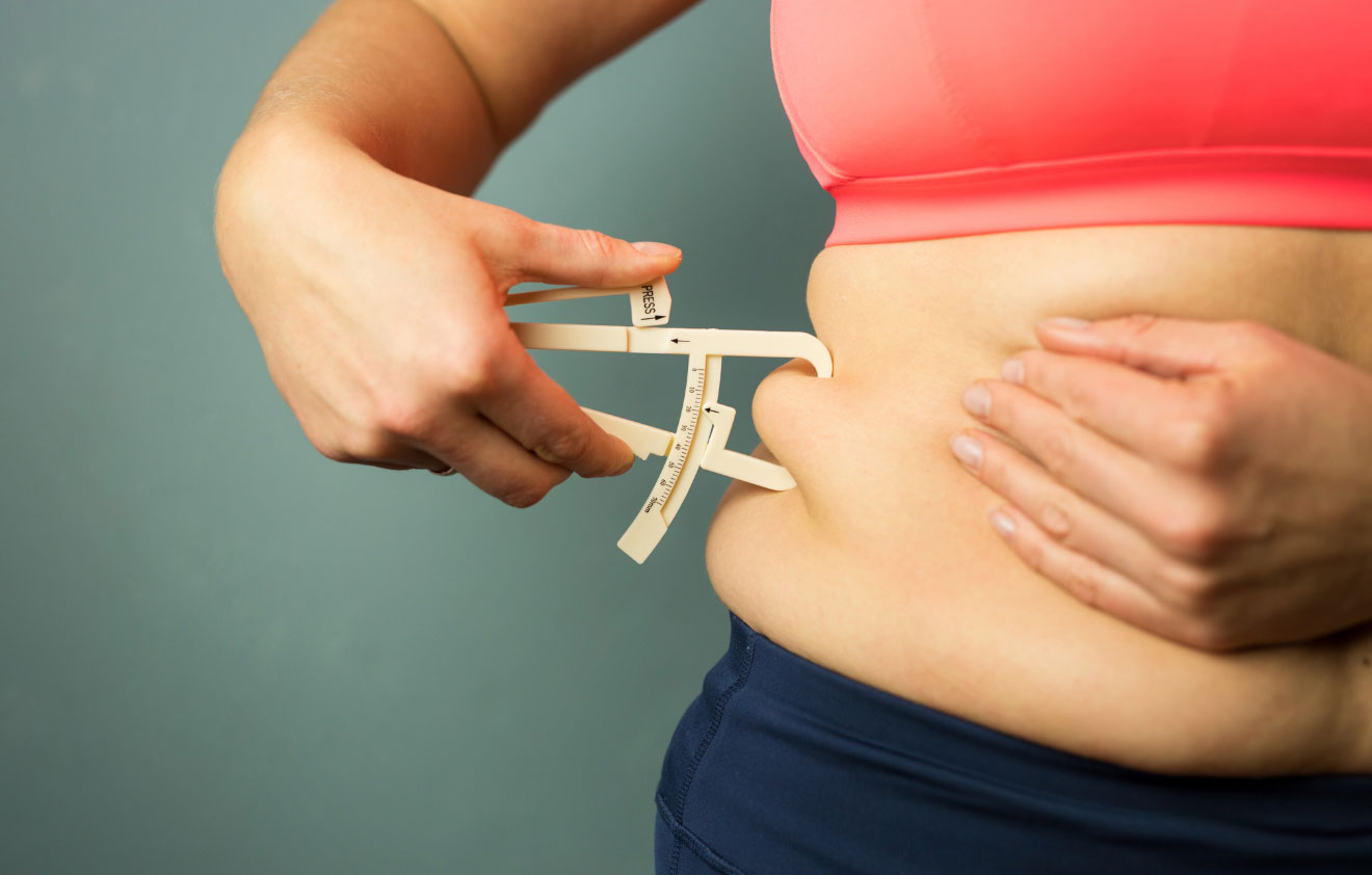 Women Measuring Belly Fat With Tool Caused Due to Harmone Imbalance